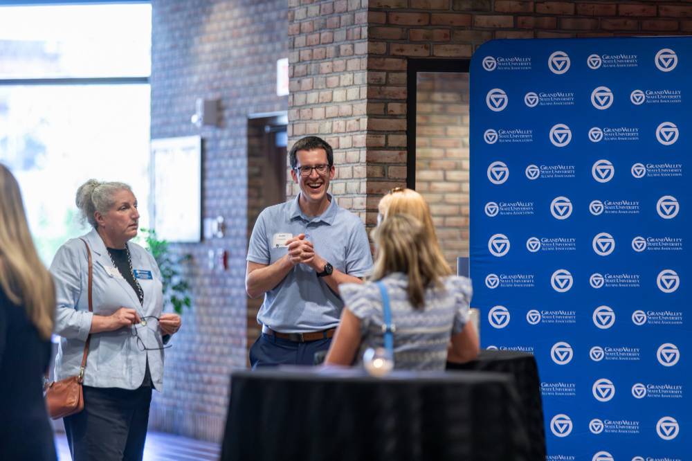 Three alums talking at the event.